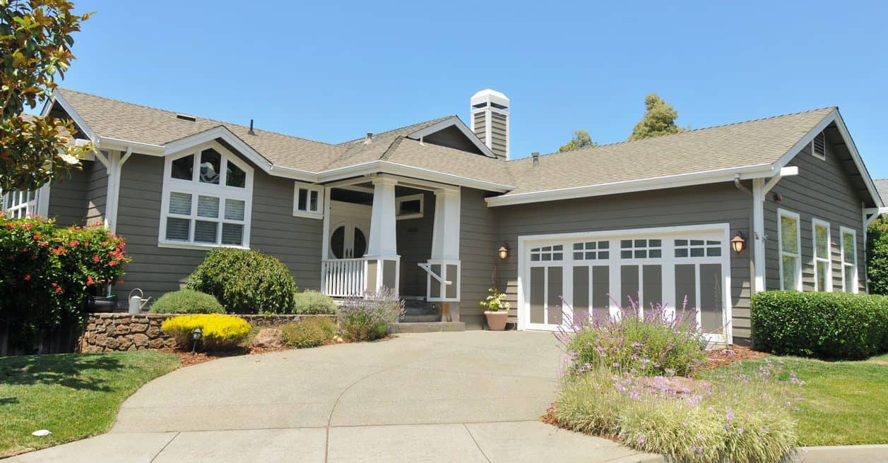 Gray Exterior House Painting Gray exterior residential house with white trim, garage doors, covered porch columns, and gable roof in Atlanta, GA