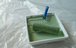 Paintroller and green paint in tray