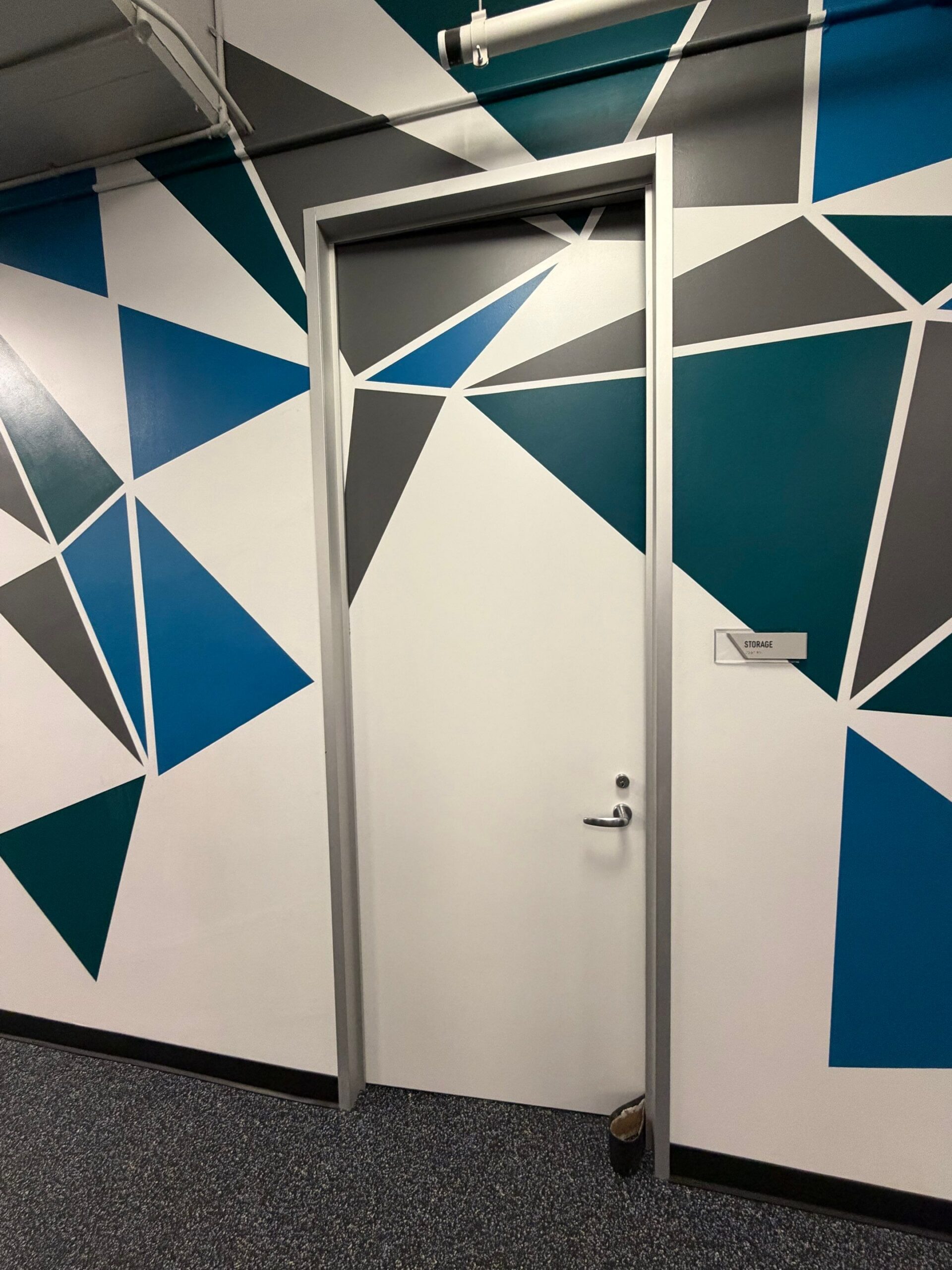 Modern Commercial Office Interior Wall Painting A modern commercial office hallway with a geometric accent wall painted in white, gray, teal, and blue.