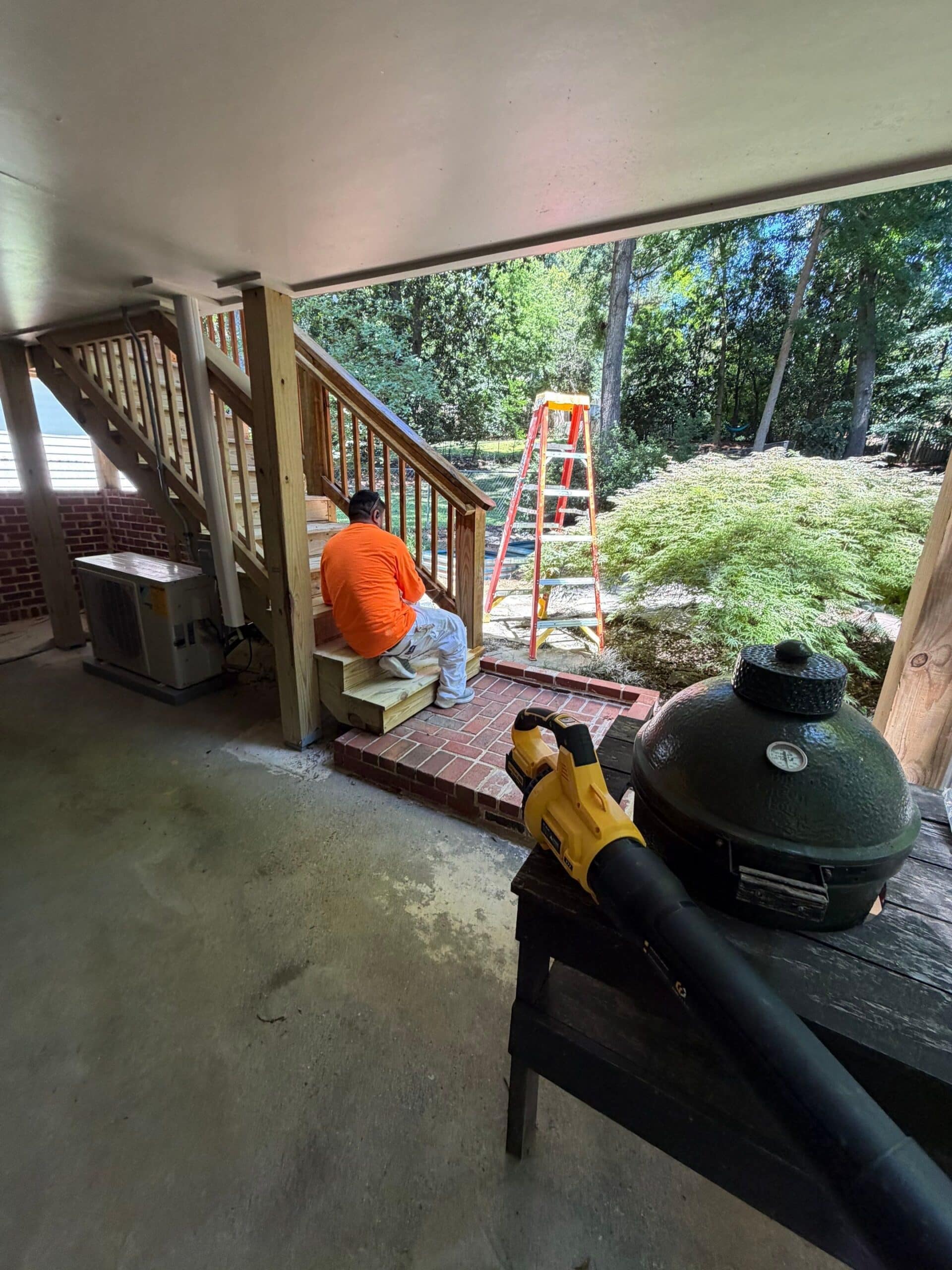 Deck Staircase Painting Project Light gray painted ceiling and walls above wood deck stairs with metal railings during residential exterior work.